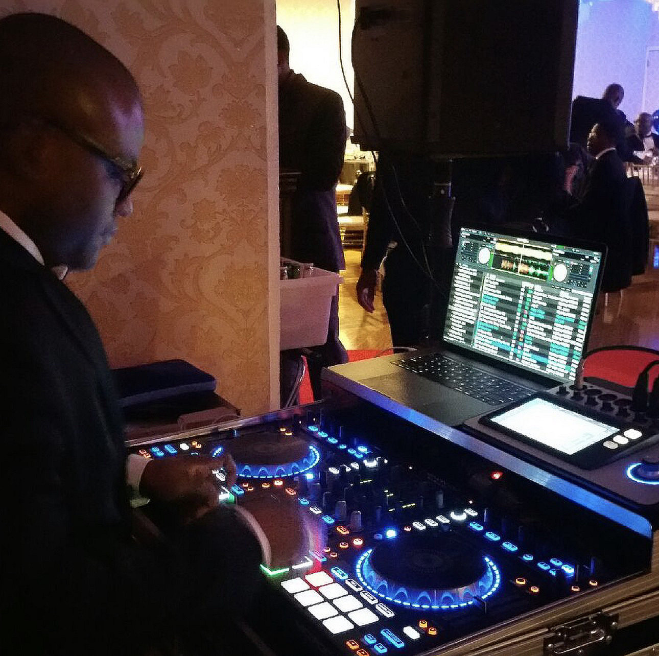 DJ Klitchko at the controller during an event, the deck lit blue against a dark room.